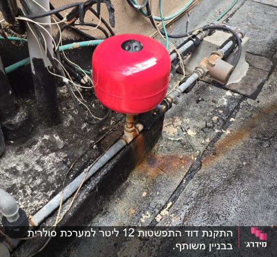 מיכל אדום מחובר לצינורות על גג